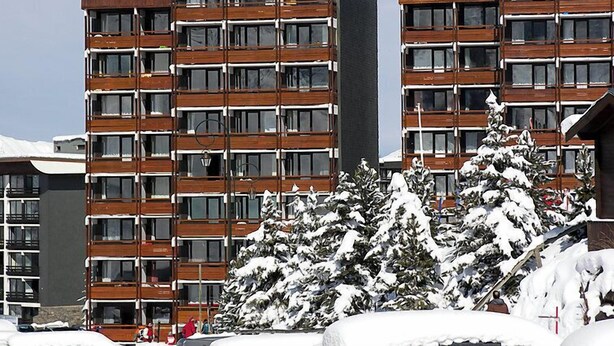Un hôtel à plusieurs étages au design moderne, doté de nombreux balcons et de grandes fenêtres.