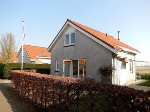Et toetagers hus med rødt tegltag, en fordør og en synlig garage.