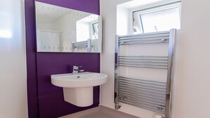 A bathroom with a white sink, purple walls, and a chrome towel rack. - University Campus Park Wood by Interhome (Canterbury)