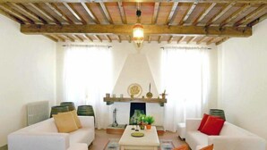 Un salon avec deux canapés blancs, une table basse et une cheminée.
