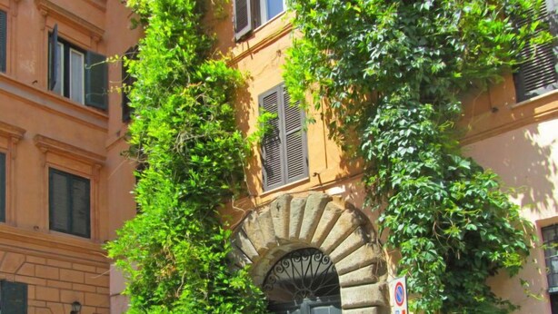 A building with a stone archway entrance, a black door, and a no parking sign. - Pantheon by Interhome (Rome: Historical City Center)