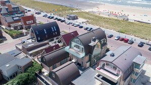 Un hôtel situé sur la côte, doté d’une architecture moderne, caractérisée par des toits incurvés et de grandes fenêtres.