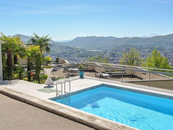 A rooftop pool with a view of mountains and a cityscape. - Residenza Monte Bré - Apt.105 Haus1 by Interhome (Aldesago)