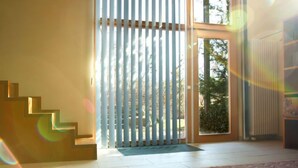 A modern interior with a staircase, a sliding glass door leading outside, and a radiator on the wall.
