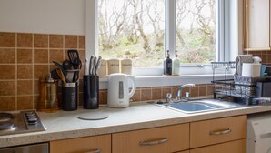 A kitchen with a window, a sink, and a stove. - Alan's House by Interhome (North Skye)