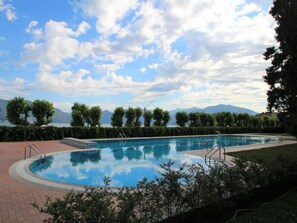 Ein Schwimmbecken mit Blick auf Berge und einen See im Hintergrund.