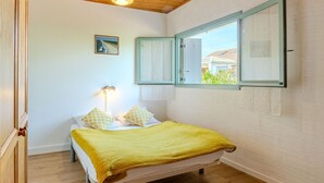 Una camera da letto con un letto, una lampada da comodino, una finestra con persiane e vista sull'esterno.