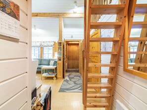 A wooden interior with a sofa, a small table, and a ladder. - Lomaylläs h105 / pistopolku 2a by Interhome (Ylläsjärvi)