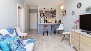 A modern apartment with a living room, kitchen, and dining area.