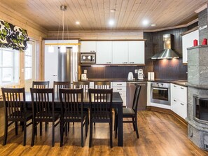A modern kitchen with wooden cabinets, a stainless steel refrigerator, and a built-in oven.