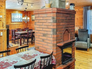 Un interior acogedor con chimenea de ladrillo, zona de comedor de madera y una barra con paredes de madera.