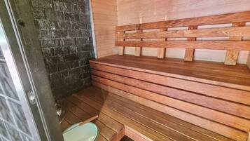 Eine Sauna mit Holzbänken und einer Steinwand.