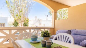 A balcony with a table set for two, a potted plant, and a decorative starfish. - Res Mediterraneo by Interhome (Deltebre)