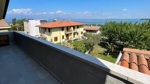 Varanda com vista para a costa, incluindo edifícios e vegetação.