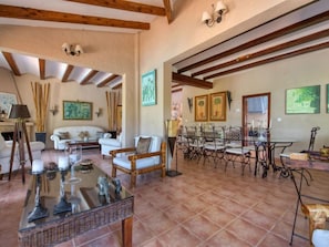 A spacious living room with a fireplace, a dining area with a table and chairs, and a balcony with a view.