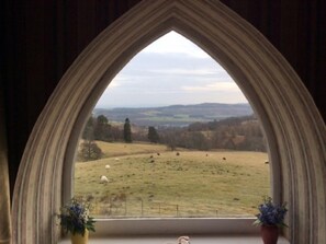 A room with a large arched window overlooking a grassy field with sheep. - Wester Riechip by Interhome (Dunkeld)
