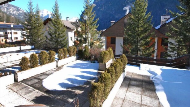 A residential area with snow-covered ground, modern houses, and a mountain backdrop. - Monti Pallidi by Interhome (Canazei)