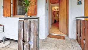 A hallway with wooden doors and a potted plant. - Monti Pallidi by Interhome (Canazei)