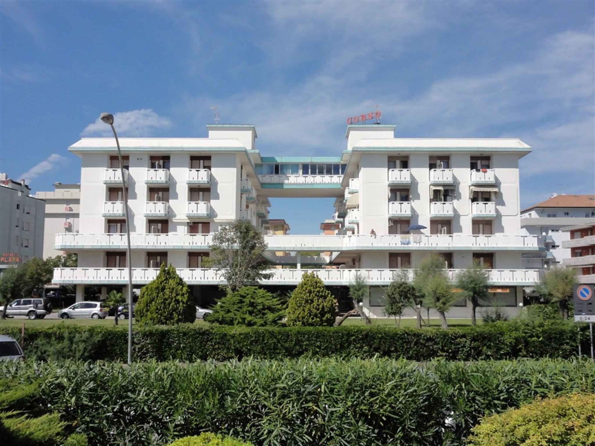 Un hôtel de taille moyenne doté d’un atrium central, de nombreux balcons et d’un espace de stationnement situé à l’avant.