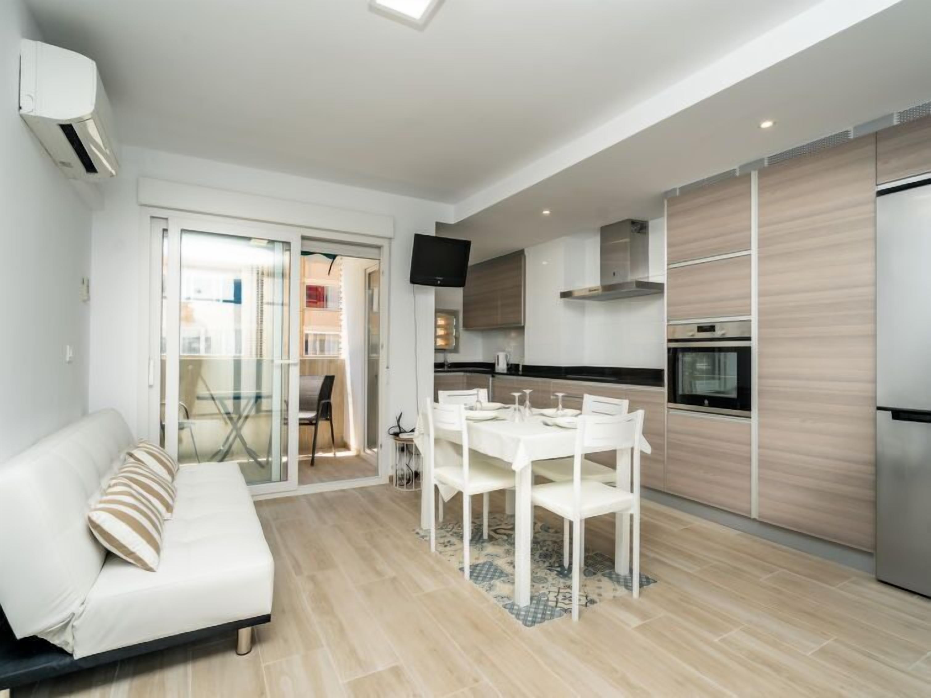 Een modern appartement met een woonkamer, eetgedeelte en keuken.