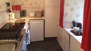 Cocina compacta equipada con microondas, tostadora y refrigerador.