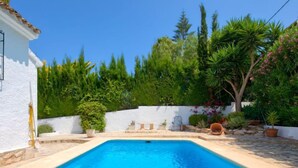 A swimming pool with a white wall and potted plants around it. - Florencia by Interhome (Jávea)