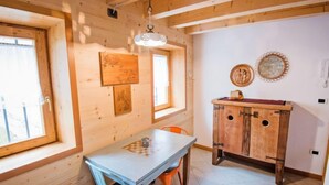 A wooden interior with a dining table, chairs, and a cabinet. - Albergo Diffuso - Cjasa Ustin by Interhome (Barcis Lake)