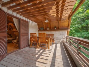 Enjoy outdoor dining or relaxation on this spacious deck with table and chairs.