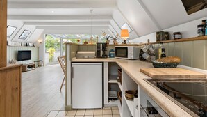 Uma cozinha moderna com ilha central, eletrodomésticos embutidos e vista para o exterior.