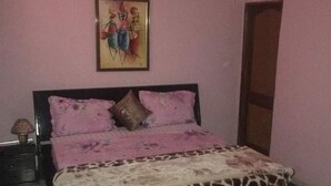 Ein Schlafzimmer mit einem Bett, einem Nachttisch, einem Bild an der Wand und einem roten Teppich.