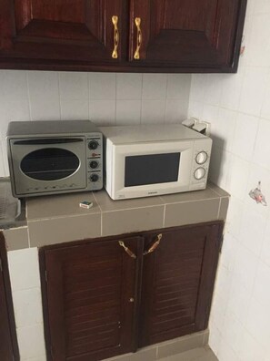 Een koelkast, een oven, een kookplaat, een koffiezetapparaat/waterkoker