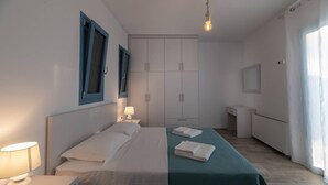 Un dormitorio moderno con cama, mesitas de noche, armario y baño.