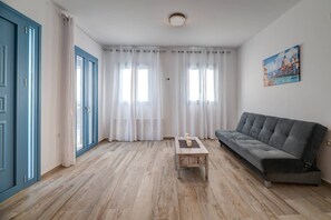A living room with a grey sofa, a wooden coffee table, and white curtains. - Quiet place for special vacations for couples! (Heraklion)