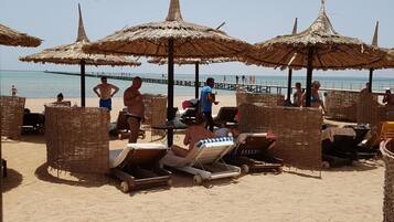 Na praia, espreguiçadeiras, toalhas de praia