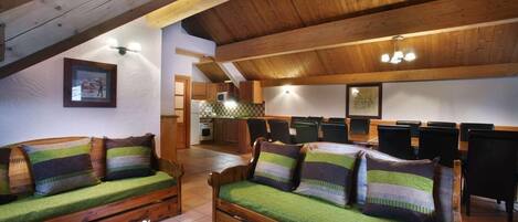 A cozy room with wooden furniture, a dining area, and a kitchen.