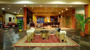 Un'ampia hall con tavolo da biliardo, comodi posti a sedere e una moquette rossa.