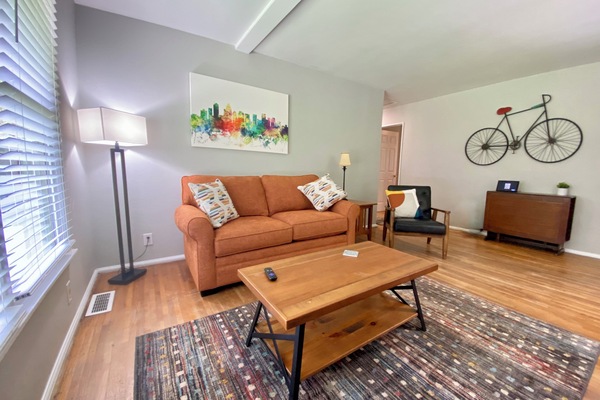 Spacious living room with hardwoods, large bay window and 54" Roku TV.