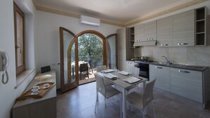 A modern kitchen with a dining area, featuring a large window, built-in cabinets, and a small dining table with chairs. - Minerva di Lone at 3 kms from Amalfi (Amalfi)