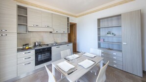 A modern kitchen with built-in cabinets, a dining table set for four, and a large window above the sink. - Minerva di Lone at 3 kms from Amalfi (Amalfi)