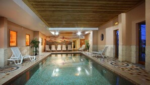 Ein Innenpool mit Liegestühlen und einem Wandgemälde.