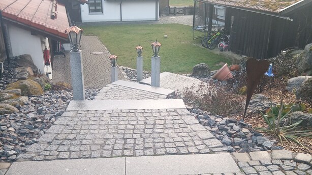 A cobblestone pathway leading to a residential area with houses, a grassy yard, and a bicycle. - Nice newly renovated apartment in a quiet location !! (Wald)