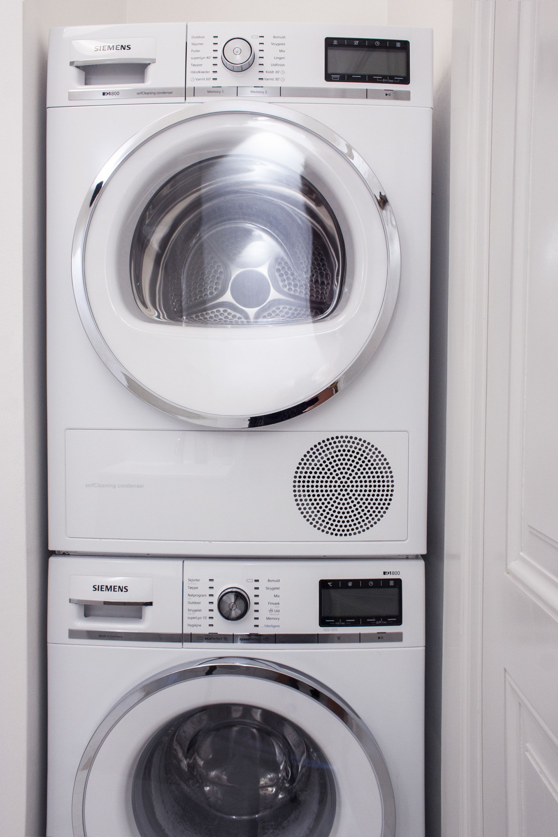 A stacked washer and dryer unit with control panels and a transparent drum.