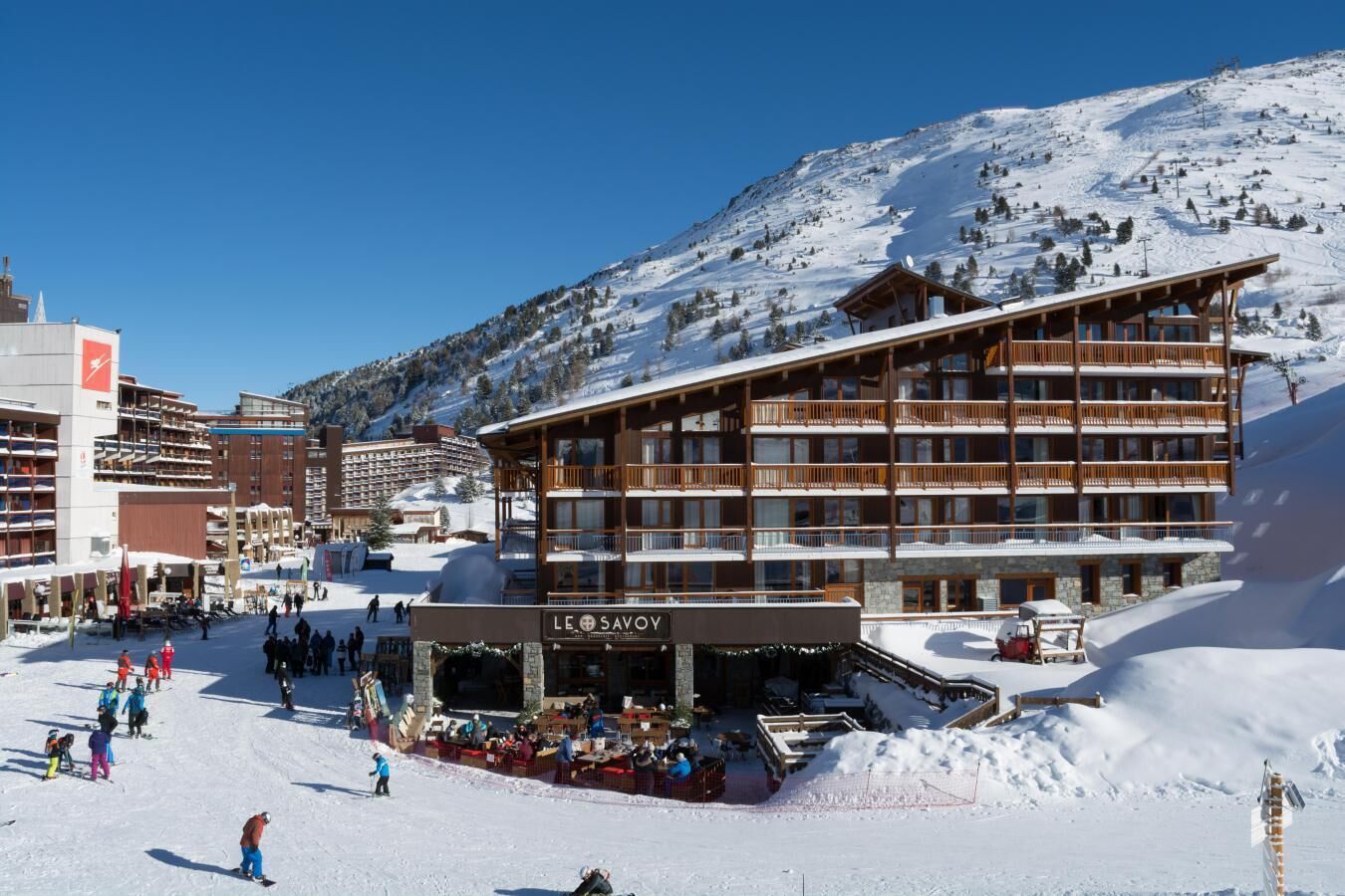 A ski resort with a multi-story building labeled "LE SAVOY."