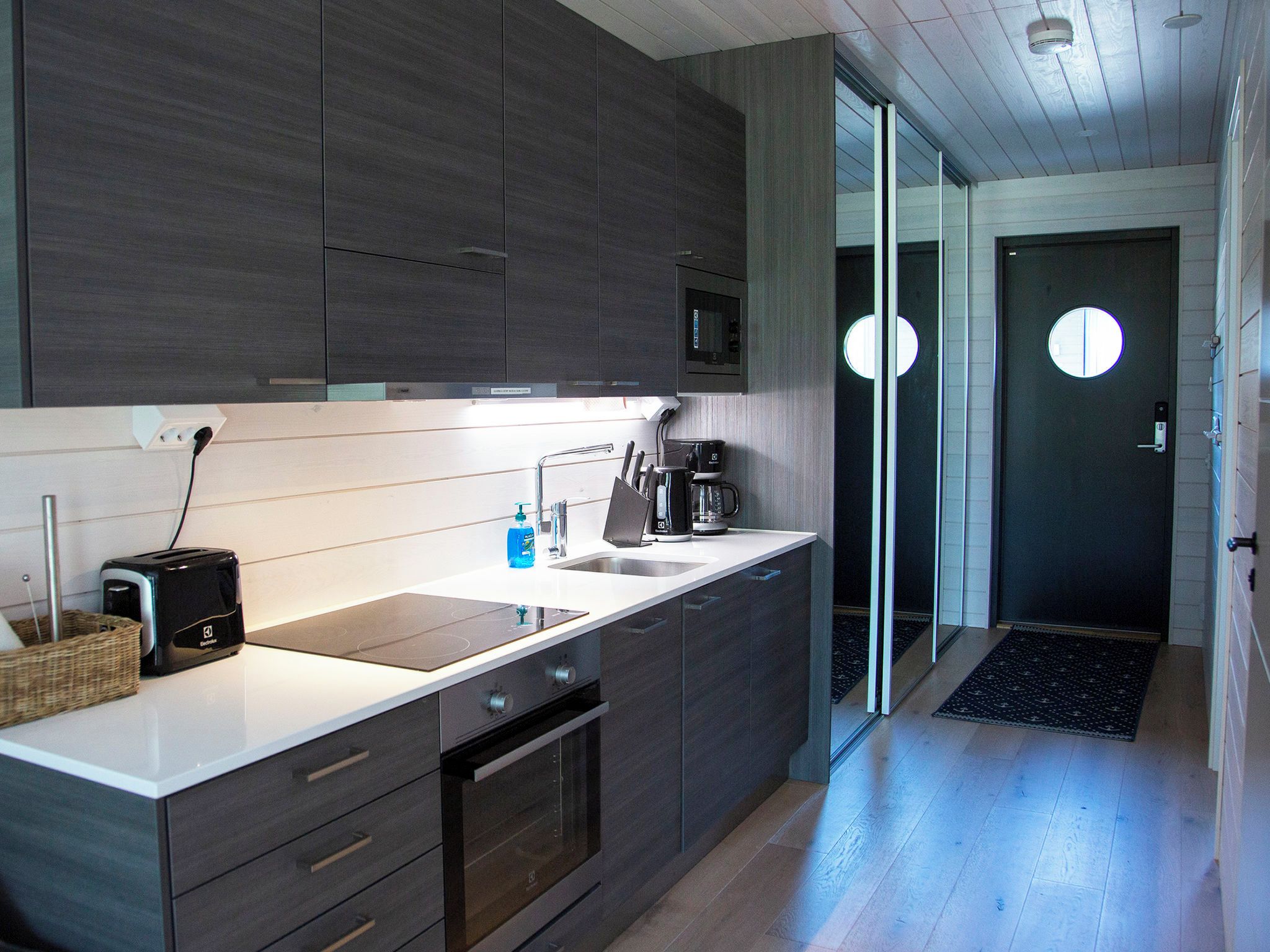 A modern kitchen with a built-in microwave, a toaster, and a coffee maker.