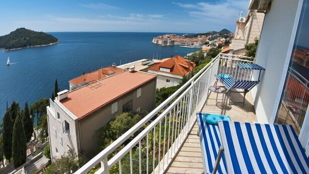 Un balcon avec vue sur la mer, une petite île et, au loin, une ville chargée d’histoire.
