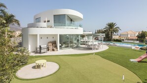 Una casa moderna de dos pisos con piscina, patio y tobogán.