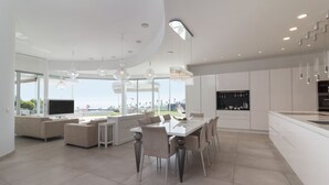 Una cocina moderna con comedor, ventanas amplias y vistas al exterior.
