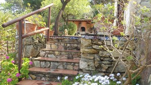 Una escalera de piedra que sube hacia un edificio rústico con un balcón de madera.