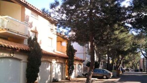 Una calle residencial con casas, árboles y un coche estacionado.