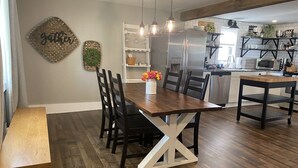 A dining area with a wooden table and chairs, a bench, and pendant lights. - Das Gästehaus • 50 Min to KC Stadium • World Cup 2026 (Concordia)